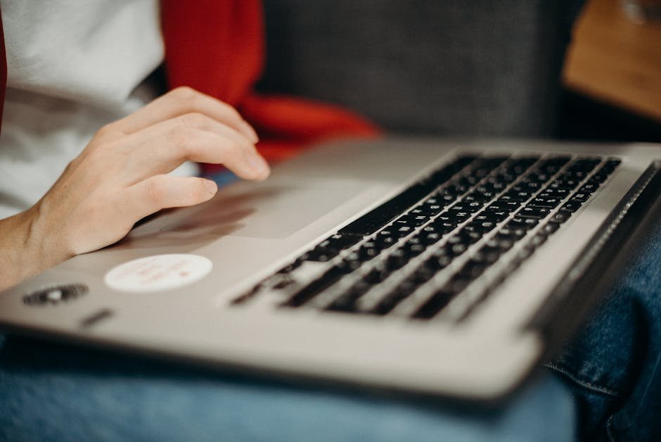 A close-up view of hands typing on a laptop keyboard, ideal for remote work contexts.