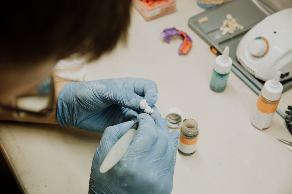 Close-up of a dental technician crafting implants in a laboratory setting, emphasizing precision and skill.